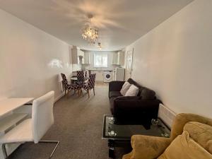 a living room with a couch and a table at The Flat in Monmore Green