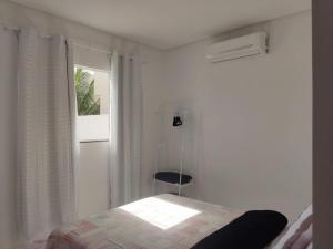 a bedroom with a bed and a window and a chair at Casa de condomínio em Paripueira in Paripueira +23 photos
