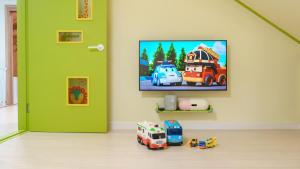 una habitación con un televisor y camiones de juguete en el suelo en Yangpyeong The On Private Kids Pension, en Yangpyeong