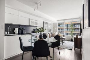 a kitchen and dining room with a table and chairs at Stylish 1BR Condo with Patio Steps from Waterfront in Toronto