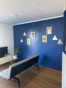 un mur bleu avec un banc dans un salon dans l'établissement Entre Rocas, à El Tabo