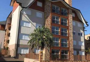 een huis met een palmboom ervoor bij Apartamento Del Veneto in Canela