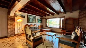 a living room with a table and chairs and a brick wall at Casa Zaragoza in Valle de Bravo