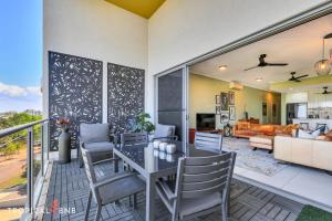 a living room with a table and chairs on a balcony at The Skyline Lookout 2 Bd Apt in Stuart Park