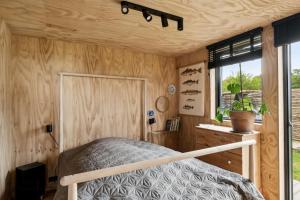 a bedroom with a bed in a wooden wall at Personal And Inventive Family House In Rødvig in Rødvig