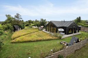 a black house in the middle of a field at Personal And Inventive Family House In Rødvig in Rødvig