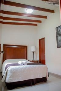 a bedroom with a bed with two towels on it at Casa Grau Chincha in Chincha +19 photos