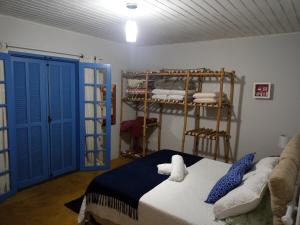 Habitación con cama y estante con toallas en Cantinho Paraíso da Mantiqueira SFX pet friendly, en São Francisco Xavier