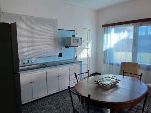 a kitchen with a wooden table and a kitchen with a sink at Corbeta in Piriápolis