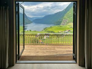 a door to a balcony with a view of a lake at Renovated Cabin With Views Over Breimsvatnet in Klakegg