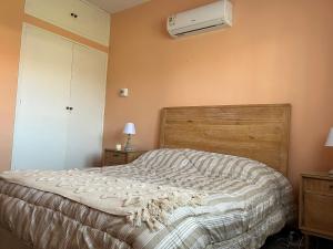 a bedroom with a bed and a air conditioner on the wall at Corbeta in Piriápolis