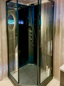 a shower with a glass door in a bathroom at Renovated Cabin With Views Over Breimsvatnet in Klakegg