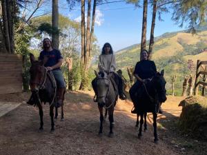 tres personas montando caballos en un camino de tierra en Cantinho Paraíso da Mantiqueira SFX pet friendly, en São Francisco Xavier