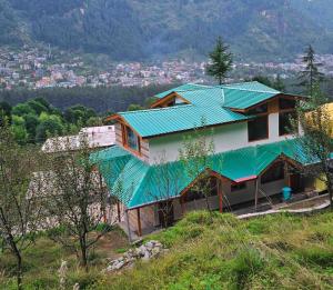 ein Haus mit Gründach auf einem Hügel in der Unterkunft Forest Nook in Manali
