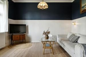 a living room with a couch and a table at Soul In A 100-Year-Old Villa On Langeland in Lejbølle