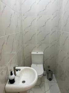 a white bathroom with a toilet and a sink at Your Home Away From Home, With Peace of Mind in Kweman