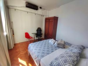 a bedroom with a bed and a red chair at Apartamentos na BARRA com VISTA MAR, a 1 minuto da praia e do Circuito do Carnaval - SEAVIEW PRIVATE APARTMENTS in Salvador