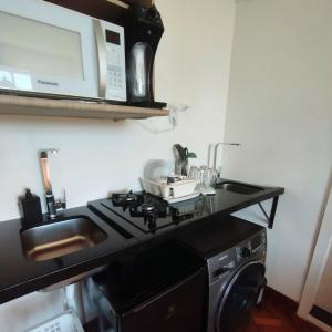 a kitchen with a stove and a microwave at Apartamentos na BARRA com VISTA MAR, a 1 minuto da praia e do Circuito do Carnaval - SEAVIEW PRIVATE APARTMENTS in Salvador