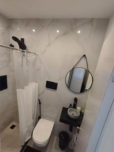 a white bathroom with a toilet and a mirror at Apartamentos na BARRA com VISTA MAR, a 1 minuto da praia e do Circuito do Carnaval - SEAVIEW PRIVATE APARTMENTS in Salvador +10 photos