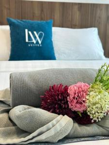 a bouquet of flowers sitting on top of a bed at Jesselton Quay Kota Kinabalu City Centre by LW Suites in Kota Kinabalu