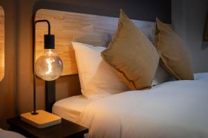 una camera da letto con letto, cuscini e lampada di Maison Raffine ad Osaka