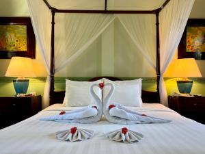two swans towels sitting on top of a bed at Villa Maly Boutique Hotel in Luang Prabang +94 photos
