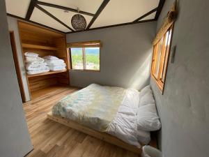 a small bedroom with a bed and a window at 月灯草津 in Wada