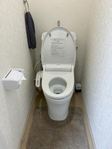 a small bathroom with a toilet with the seat up at COMMA House in Yokohama