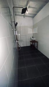 a room with a shower and a table in it at D Sebuluh Guest House in batumadeg
