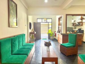 a living room with a green couch and a table at Jess Beach Villa in Galle