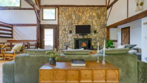 ein Wohnzimmer mit 2 Sofas und einer Steinmauer in der Unterkunft Historic Barn Retreat w Pool Pond Views Longview Pond Lodge by AvantStay in Clinton Corners