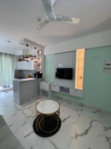 グルガオンにあるWhite Grass3 Cozy Apt in Gurgaonのテーブルとキッチンのあるリビングルーム