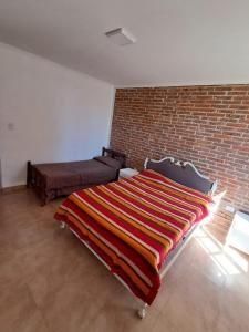 a bedroom with a bed and a brick wall at La Esquina in Paraná