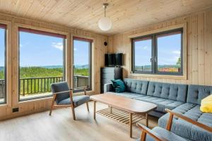 een woonkamer met een bank en een tafel bij Mountain Cabin With Panoramic Views In Norefjell in Runn
