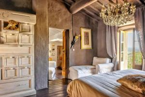 a bedroom with a bed and a chandelier at Tuscan Country House With Pool And Spa in Capolona +20 photos