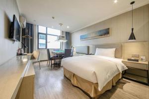 a bedroom with a large bed and a dining room at Borrman Hotel Wuhan Yangluo Metro Station Shenshuigang in Wuhan +87 photos