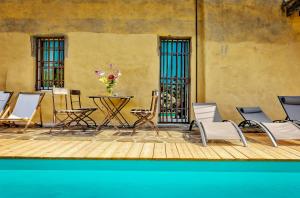 a patio with chairs and a table with a vase of flowers at Tuscan Country House With Pool And Spa in Capolona