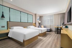 a hotel room with two beds and a television at Echarm Hotel Yingshang High-speed Railway Station Wuzhou Wanhui Plaza in Fuyang +185 photos