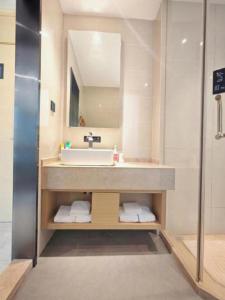 a bathroom with a sink and a mirror at City Comfort Inn Xiaogan Xiaochang Bus Passenger Station in Xiaogan +227 photos