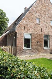 a brick house with two windows and a fence at Het Centrum in Norg