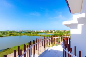 a view of a lake from a balcony with a fence at The Retreat by the Ocean - Happy Life Memories Hoi An Hotel & Spa in Hoi An