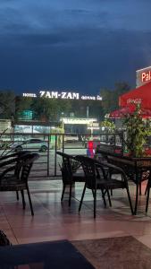a group of tables and chairs on a patio at night at Zam-Zam Hotel Turkestan in Türkistan +66 photos