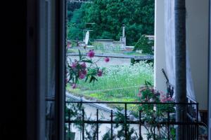 een raam met bloemen en uitzicht op een tuin bij George Apartment in Zagreb