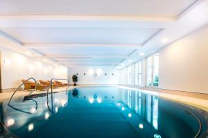 ein Schwimmbad in einem Gebäude mit einer Person im Hintergrund in der Unterkunft Collegium Leoninum in Bonn