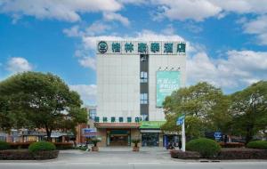 a large white building with a sign on it at Green Tree Inn Fengxian New City Metro Station Jiukeshu Art Center in Shanghai