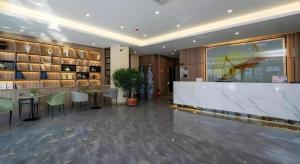 a lobby with a bar and tables and shelves at GreenTree Inn Express Hebei Tangshan Guyan District Xinguang Road in Tangshan
