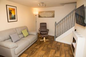 a living room with a couch and a chair at Plover Cottage in Huddersfield