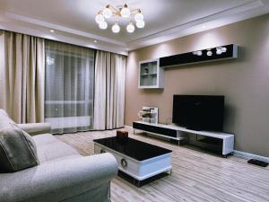 a living room with a couch and a flat screen tv at Cozy furnished Brand-New City Center UB Apartment in Ulaanbaatar
