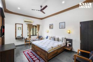 une chambre avec un lit, une table et des chaises dans l'établissement StayVista at Samar Fateh Garh with Bonfire, Lawn, AC, à Rāma 26 autres photos