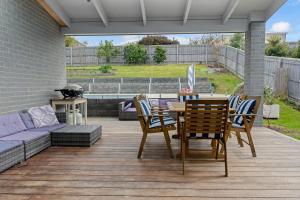 a patio with a table and chairs and a couch at Tea Tree Pool Retreat in Inverloch